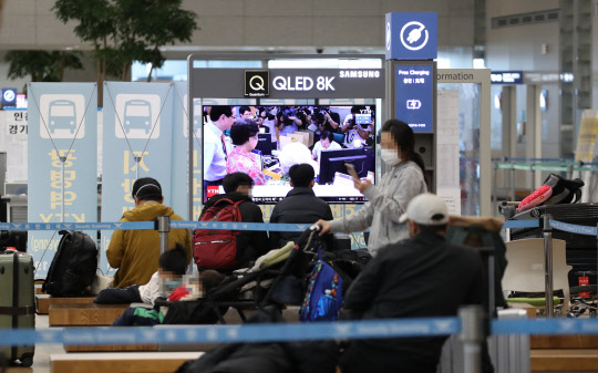 전국 공항을 통해 입국하는 외국인들에 대한 유전자증폭(PCR) 검사 음성 확인서 제출 의무화 조치가 시행된 8일 오전 인천국제공항 제2터미널 입국장에서 입국자들이 대기하고 있다. 연합뉴스